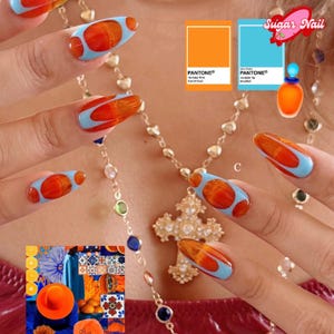 Puede incluir: Primer plano de uñas manicuradas con un diseño vibrante. Cada uña presenta una base azul claro con acentos naranjas y marrones. La imagen incluye muestras de color Pantone y elementos decorativos, mostrando un tema de arte de uñas.