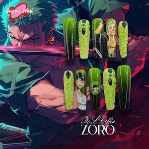 May include: A set of long, coffin-shaped artificial nails with a green and black gradient design. Some nails feature anime character art, textured green accents, and gem embellishments. The text "Sugar Nail" and "ZORO" are visible.