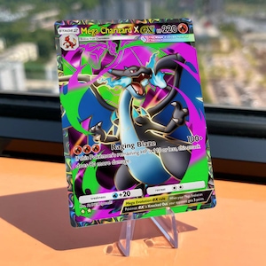 Puede incluir: Una carta coleccionable Pokémon Mega Charizard X EX. La tarjeta presenta un diseño vibrante con una ilustración de Charizard, con el texto "Raging Blaze" y "Mega Evolution EX rule". La tarjeta se muestra en un soporte transparente.