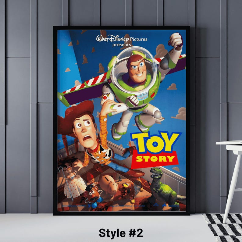 May include: A framed poster featuring the Toy Story movie. The poster shows Buzz Lightyear in a green and white spacesuit, Woody in a cowboy hat, and other characters. The title "Toy Story" is in large, colorful letters.