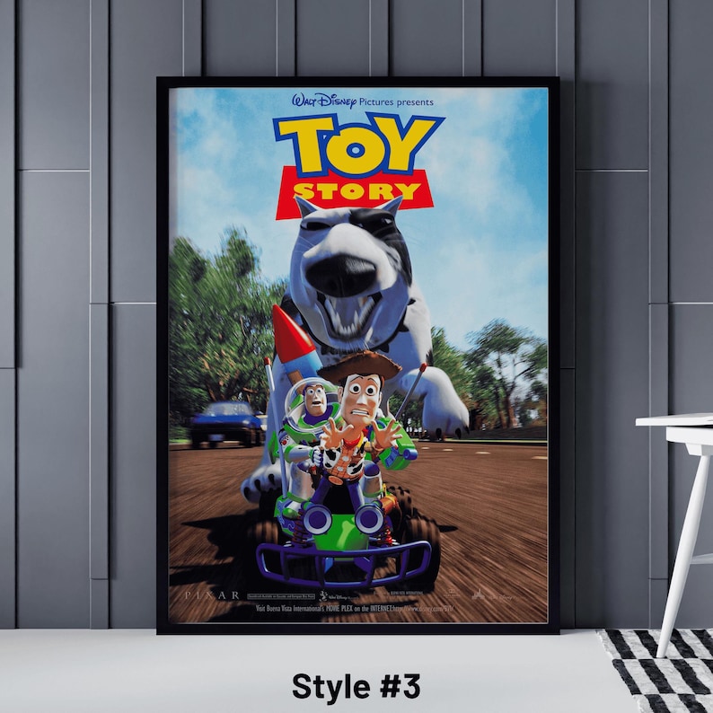 May include: Framed poster featuring the Toy Story movie. The poster shows the characters Woody, Buzz Lightyear, and others in a race scene. The title "Toy Story" is prominently displayed in large, colorful letters. The poster is framed in black.