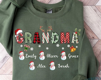 May include: Military green sweatshirt with the word "GRANDMA" in a festive design. The letters are decorated with plaid, stripes, and holiday patterns. Below the word are the names Emily, Oliver, Grace, Alex, and Sarah, with snowman graphics.