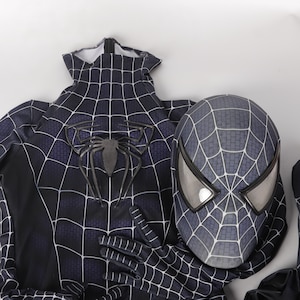 Op de afbeelding: Zwart en grijs Spider-Man kostuum met een zwart webontwerp en een bijpassend masker. Het masker heeft een zwart webontwerp en een grijs spinnenlogo.