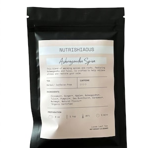 May include: A black resealable pouch containing Nutrishiaous Ashwagandha Spice loose leaf tea. The white label lists ingredients including cinnamon, ginger, apple, ashwagandha, tulsi, pumpkin, sea buckthorn, cardamom, and nutmeg. Net weight 25 grams.