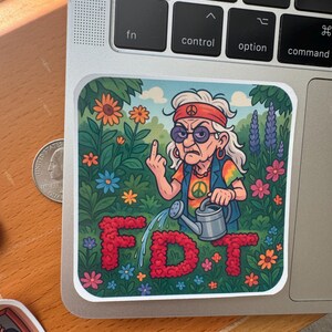 May include: A colorful sticker featuring an elderly woman with sunglasses and a peace sign shirt, giving the middle finger. She is watering red flower letters that spell "FDT" in a garden setting with various flowers.
