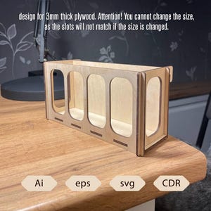 Könnte beinhalten: Ein helles Holz-Organizer mit vier rechteckigen Fächern und abgerundeten Öffnungen. Der Text auf dem Bild besagt, dass es für 3 mm dickes Sperrholz konzipiert ist und die Größe nicht geändert werden kann. Das Bild enthält auch die Dateitypen: Ai, eps, svg und CDR.