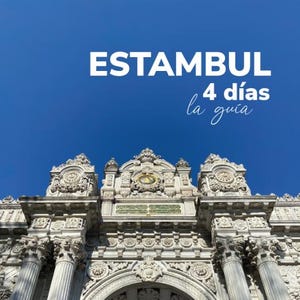 Puede incluir: Un arco de piedra blanca con intrincados tallados y esferas de reloj. El arco forma parte de un edificio más grande y se encuentra sobre un cielo azul brillante. El texto "ESTAMBUL 4 días la guía" está superpuesto a la imagen.