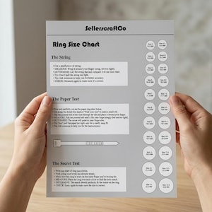 Puede incluir: Una tabla de tallas de anillos de SellerscraftCo es sostenida por una persona. La tabla incluye instrucciones para medir la talla del anillo utilizando los métodos de la cuerda, el papel y la prueba secreta. La tabla tiene un fondo gris con texto negro y círculos blancos con tallas de anillos en milímetros.