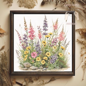 May include: A framed floral cross-stitch featuring a vibrant meadow scene. The artwork showcases a variety of wildflowers in shades of pink, yellow, and purple, with green foliage and small rocks at the base. The frame is dark brown.