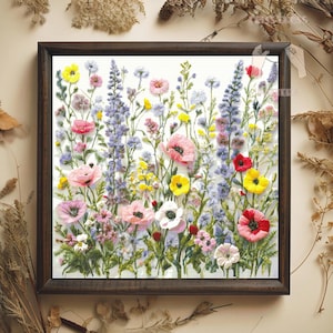 Può includere: Un ricamo floreale incorniciato con una vibrante serie di fiori colorati. L'opera presenta papaveri rosa, margherite gialle e lupini viola, il tutto su uno sfondo bianco. La cornice è di colore marrone scuro.