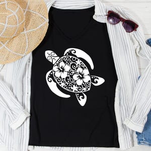 May include: Black V-neck t-shirt featuring a white sea turtle design. The turtle is decorated with floral and swirl patterns. The shirt is styled with a straw hat, sunglasses, and a white button-down shirt.