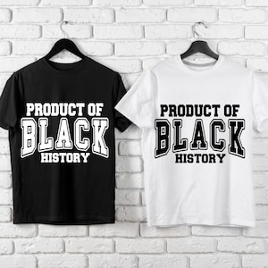Puede incluir: Dos camisetas de manga corta, una negra y otra blanca, cuelgan contra una pared de ladrillos blancos. Cada camiseta muestra el texto "PRODUCT OF BLACK HISTORY" en letras blancas y en negrita, estilo universitario.