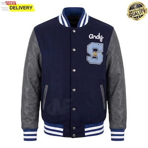 Puede incluir: Chaqueta universitaria azul marino con mangas de cuero gris. Cuenta con un parche "S" azul claro con un gráfico de baloncesto y el nombre "andy" en escritura. La chaqueta tiene puños y cuello a rayas blancas y azules.