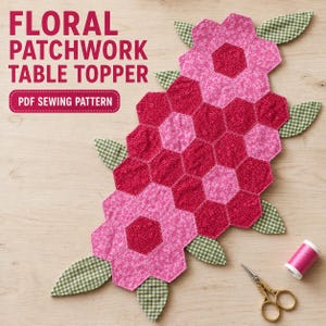 Op de afbeelding: Een PDF-naaipatroon voor een bloemrijke patchwork-tafelloper met roze en rode zeshoekige stoffen stukjes in bloemvorm met groen-wit geblokte bladeren. Inclusief een klosje roze garen en een gouden schaar in de hoek.