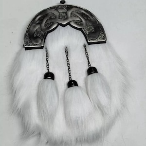 Pu&ograve; includere: Una sporran di pelliccia bianca con un cantle decorativo color argento con un intricato disegno a nodo celtico. Tre nappe bianche pendono dal basso, attaccate da catene nere. Un accessorio scozzese tradizionale.