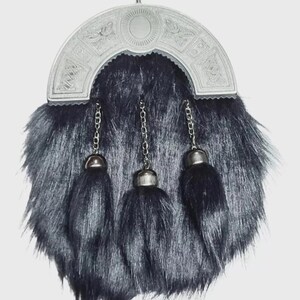May include: A traditional Scottish sporran with a silver cantle and three black tassels. The sporran has a fur body and silver chain details. The cantle features intricate Celtic knotwork and a central oval design.