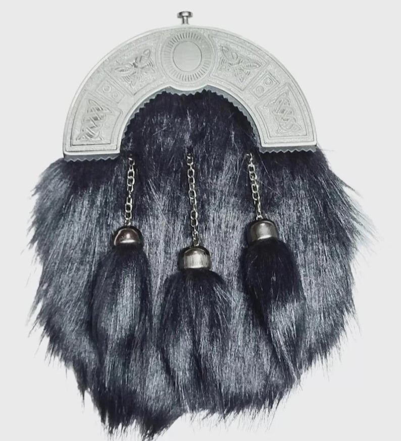 May include: A traditional Scottish sporran with a silver cantle and three black tassels. The sporran has a fur body and silver chain details. The cantle features intricate Celtic knotwork and a central oval design.