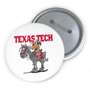 May include: A white button with a cartoon illustration of a man riding a horse, with the words "TEXAS TECH" in red. The button has a metal pin back.
