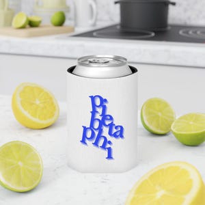 May include: A white can cooler with the blue text "Pi Beta Phi" is shown, with a silver can inside. The background includes cut lemons and limes. The cooler is designed to keep beverages cold.