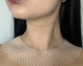 May include: A white beaded collar necklace featuring a delicate, interconnected diamond-shaped lattice pattern. The intricate design sits flat against the neck, crafted from small, uniform beads that create a lightweight, open-work structure.