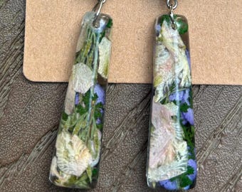 Favored. Dangle earrings, unique shape, real pressed flowers, green and tan beads, clear resin.