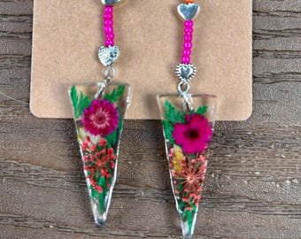 Glamorous. Dangle earrings, unique shape, real pressed flowers, pink and orange beads with silver hearts and clear resin.