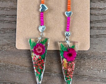 Glamorous. Colorful real flowers in clear resin, accompanied by vibrant beads bring these earrings to another level. Dress with flair.
