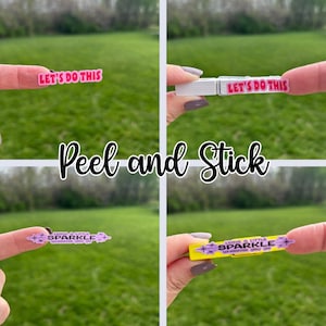 Peel and stick cheer clip stickers shown before and after being applied to clothespins. Close-up collage shows motivational cheer stickers like “Let’s Do This” and “Leave a Little Sparkle Wherever You Go,” ideal for decorating cheer clips, team spirit pins, and cheerleading bag tags.