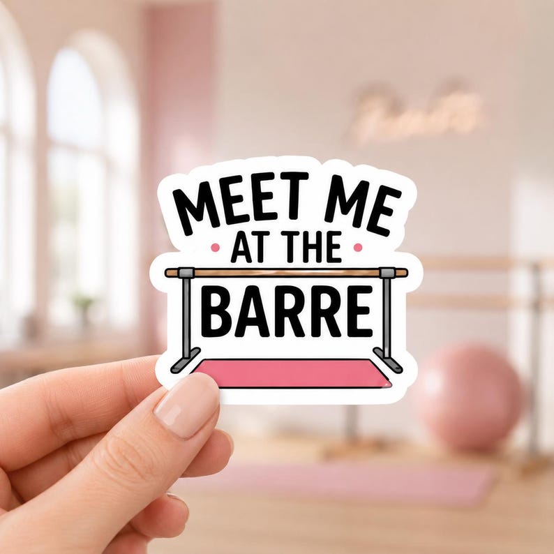 A hand holding a white sticker with a black border that says MEET ME AT THE BARRE in capital letters. This cute studio-themed sticker is perfect for pilates lovers to use on their planners or water bottles.
