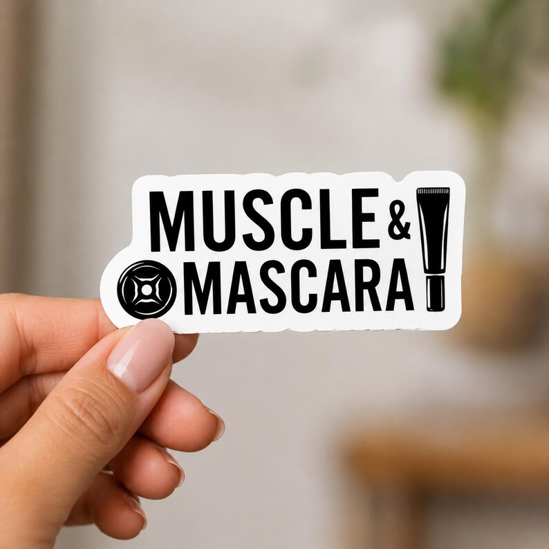 A hand with manicured nails holding a white sticker that says MUSCLE & MASCARA with small weight icons. This sticker highlights the intersection of femininity and strength in the powerlifting decals for women set.