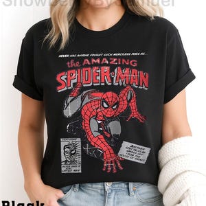 a woman wearing a black spider - man t - shirt
