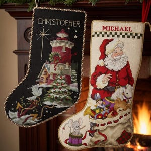 Może przedstawiać: Dwie świąteczne skarpety wiszą na kominku. Jedna jest czarna z motywem latarni morskiej i imieniem "CHRISTOPHER". Druga jest kremowa z motywem Świętego Mikołaja i imieniem "MICHAEL". Obie skarpety mają ozdobne sznurowe wykończenie.