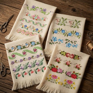 May include: Four off-white embroidered towels with floral designs. Each towel features a different border pattern with colorful flowers and green leaves. The towels have fringed edges and are arranged on a wooden surface.