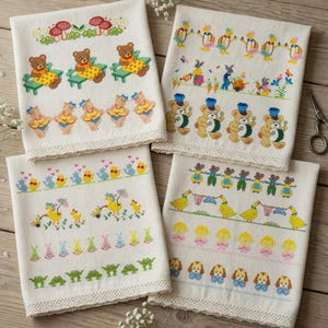 Puede incluir: Cuatro paños de cocina bordados en color crema con varios diseños coloridos. Los diseños incluyen osos de peluche, patos, conejitos y otros personajes caprichosos. Cada paño tiene un borde de encaje decorativo.