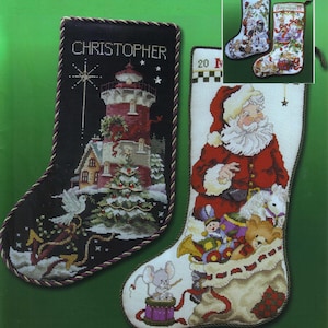 May include: Cross-stitch Christmas stockings. One black stocking features a lighthouse scene with the name "CHRISTOPHER". The other stocking depicts Santa Claus with a bag of toys. Two smaller stockings are in the upper right corner.