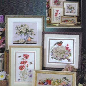 Puede incluir: Una colección de arte de punto de cruz enmarcados con temas florales y de la naturaleza. La obra de arte incluye imágenes de flores en jarrones, amapolas con abejas y un pájaro posado en un sombrero. Los marcos tienen varios estilos y colores.