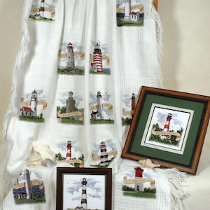 May include: White throw blanket with multiple embroidered lighthouse designs. Two framed lighthouse pictures are also displayed. The lighthouses are depicted in various colors and styles, with banners and coastal scenery.