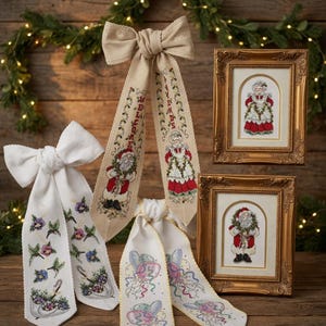 Op de afbeelding: Kerstversieringen met geborduurde linten en ingelijste kruissteekkunst. De linten hebben strikaccenten en tonen ontwerpen van de kerstman en mevrouw Claus, samen met de woorden "Welcome" en "Friends". De ingelijste kunst toont de kerstman en mevrouw Claus.