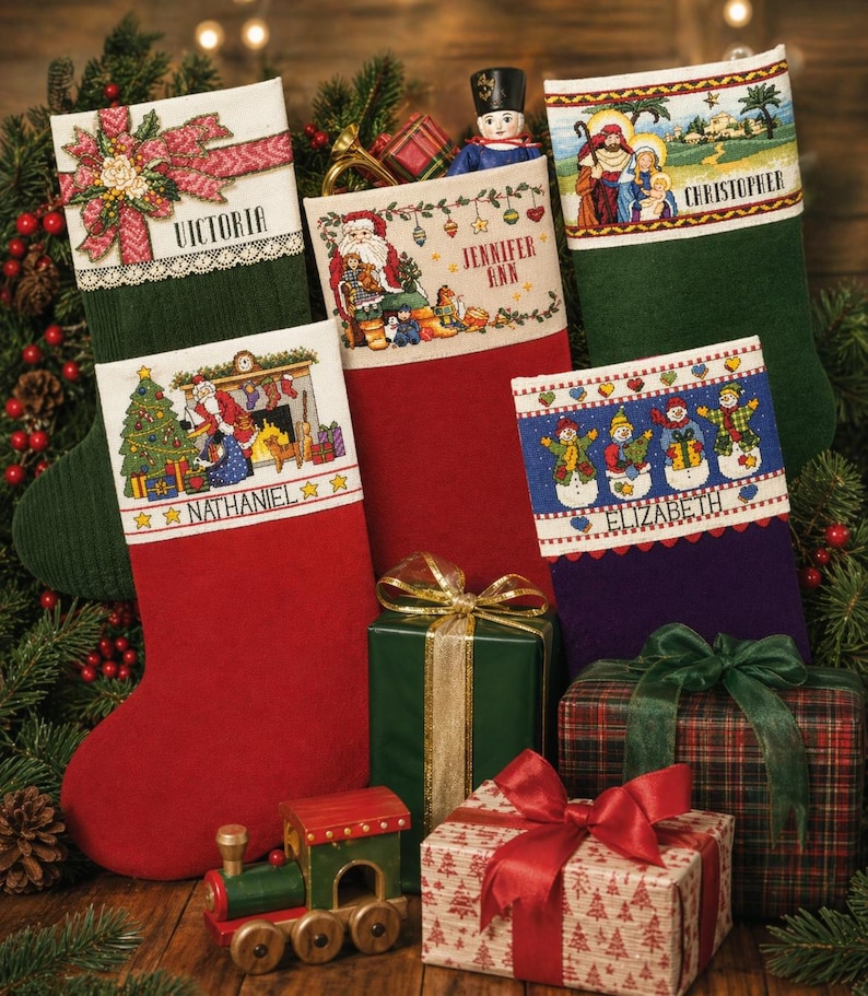 May include: Christmas stockings in red, green, and purple with embroidered designs and names: Victoria, Jennifer Ann, Christopher, Nathaniel, and Elizabeth. Presents wrapped in green, plaid, and patterned paper with bows. A toy train is also present.