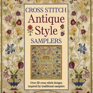 Op de afbeelding: Boekomslag met de titel "CROSS STITCH Antique Style SAMPLERS" in bordeauxrood en zwart. De omslag toont een ingelijste sampler met een huis en een bloemenrand, omgeven door een bloemenpatroon. De tekst luidt "Over 30 cross stitch designs inspired by traditional samplers."