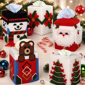Könnte beinhalten: Eine Sammlung dekorativer Taschentuchbox-Hüllen mit Weihnachts- und Wintermotiven. Designs umfassen einen Schneemann, den Weihnachtsmann, einen Bären, Weihnachtsstern und Weihnachtsbäume. Jede Box ist aus Garn und quadratisch.