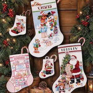 May include: Several Christmas stockings with festive embroidered designs. The stockings depict Santa Claus, snowmen, and other seasonal characters. Some stockings are personalised with names, and candy canes are attached for decoration.