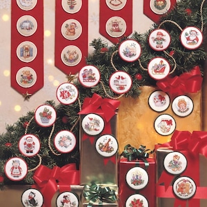 Può includere: Un'esposizione festosa di ornamenti natalizi e regali confezionati. Gli ornamenti rotondi, ricamati con scene di festa, sono rifiniti in rosso. I regali sono avvolti in carta dorata e rossa, adornati con fiocchi rossi e disposti con rami sempreverdi.