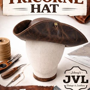 Op de afbeelding: Een bruine leren steek, een driekantige hoed, tentoongesteld op een mannequinhoofd. De hoed heeft een kenmerkende driekantige rand en is vastgezet met een messing knoop. De afbeelding bevat de tekst "DIY TRICORNE HAT" en "PDF PATTERN".