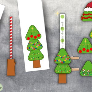 May include: A collection of Christmas-themed paper cutouts and decorations. The image features green Christmas trees with various ornaments, a red and white striped straw, and the text "en sapin de No&euml;l".