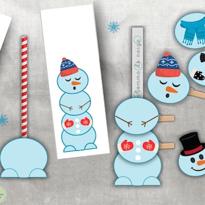 Op de afbeelding: Een verzameling lichtblauwe papieren sneeuwpopuitsparingen en accessoires. De sneeuwpoppen hebben oranje wortelneuzen, rode wanten en blauwe hoeden. Accessoires zijn onder meer een rood-wit gestreepte rietje en een zwarte hoge hoed.