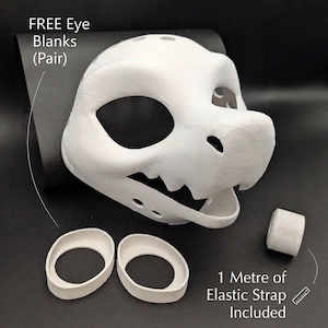May include: A white, 3D-printed dinosaur mask with large eye openings and a toothed jaw. Includes a pair of eye blanks and a roll of elastic strap. Text on the image reads "FREE Eye Blanks (Pair)" and "1 Metre of Elastic Strap Included."