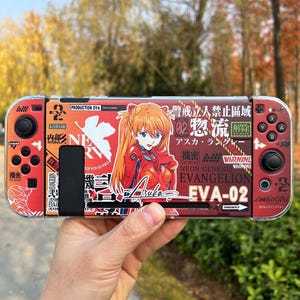 Könnte beinhalten: Rote und schwarze Nintendo Switch-Hülle mit einem Anime-Charakter-Grafik und japanischem Text. Die Hülle zeigt den Text "Neon Genesis Evangelion EVA-02".