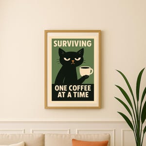 Peut inclure: Une affiche encadrée avec un chat noir tenant une tasse de café et le texte « SURVIVING ONE COFFEE AT A TIME ». L'œuvre d'art est encadrée en bois, au-dessus d'un canapé beige avec des coussins orange et crème.