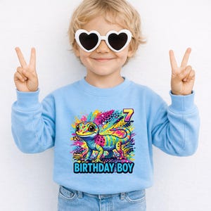 Custom Gecko Birthday Boy Shirt, Rainbow 90s inspired Gecko,y2k colorful,Maximalist Adult Kids.Make her milestone truly unique with this customizable neon-rainbow Gecko birthday shirt! Whether she is turning one, seven, or ten, you can personalize this vibrant design with any age to match her special celebration. This eye-catching cub design is perfect for the birthday girl who loves bright colors and wild adventures.